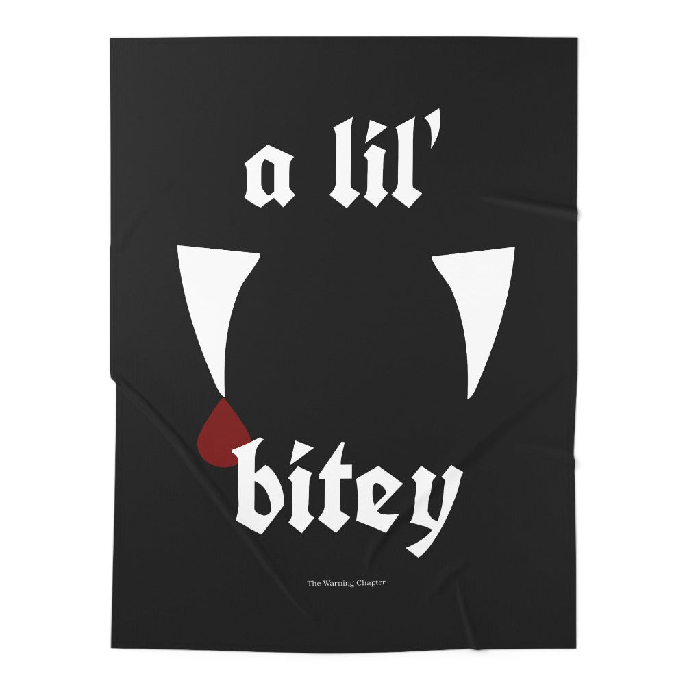 Black gothic baby blanket featuring the phrase a lil’ bitey with white vampire fangs and a red blood drop design.