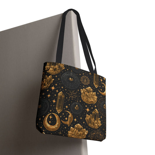 Black tote bag with crystals, stars, and moons hanging on a white end of cubicle board